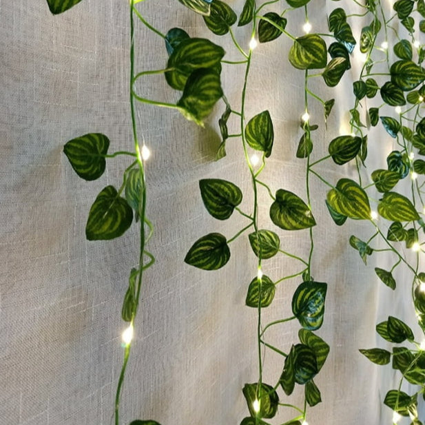 Close-up of leaf vine string lights draped over mantle.