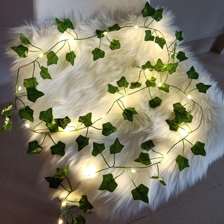 Leaf vine string lights resting on pillow, cozy aesthetic.