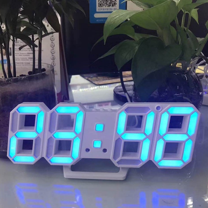 VibeCore 3D LED Digital Alarm Clock in white with blue light, featuring bold, illuminated 3D LED digits for easy time readability. This modern alarm clock includes a thermometer, perpetual calendar, and moon phase display. Its sleek white design with blue light adds a stylish, contemporary touch, perfect for enhancing any room with both functionality and aesthetic appeal.