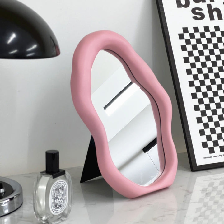 VibeCore Abstract Blob Makeup Mirror in Light Pink, adding a soft, modern aesthetic to any vanity or tabletop with its unique shape and chic pastel tone.