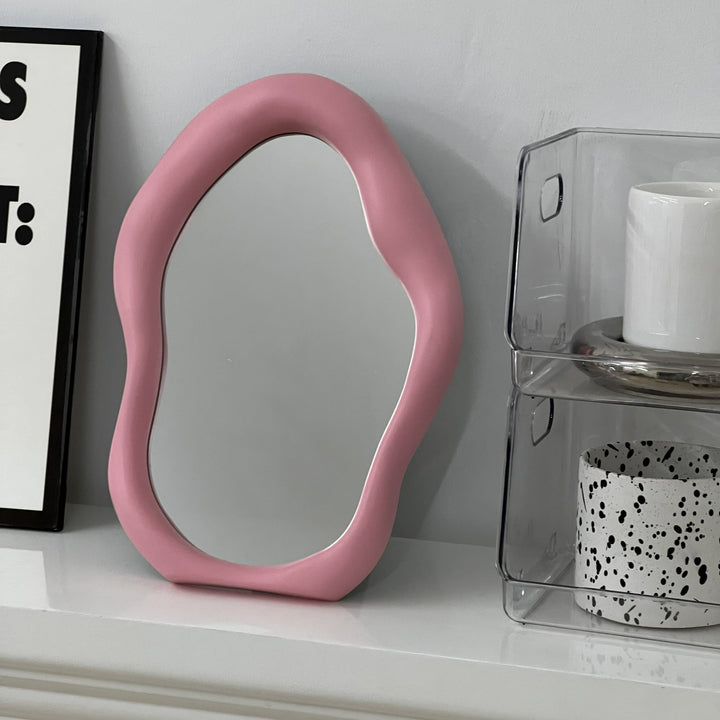 VibeCore Abstract Blob Makeup Mirror in Light Pink, elegantly placed on a fireplace mantel, bringing a modern and playful touch to your space.