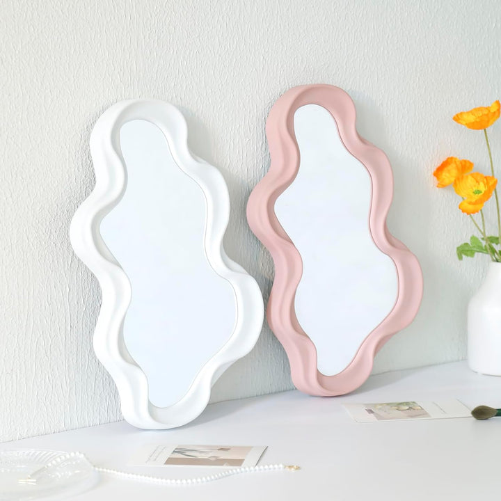 VibeCore Abstract Curve Wall Mirror Light Pink and White Ripple Against Wall: A light pink and white ripple-patterned abstract wall mirror positioned against a wall, adding a modern, artistic touch to any room with its unique, curved design.