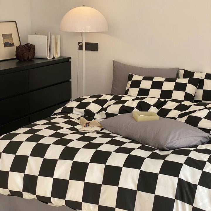 Front left view of the VibeCore Aesthetic Checkered Duvet Cover Set in black and white, featuring a bold checkered pattern crafted from 100% ultra-soft cotton. Designed to bring a modern and chic vibe to any bedroom or dorm, combining breathable comfort with effortless style.