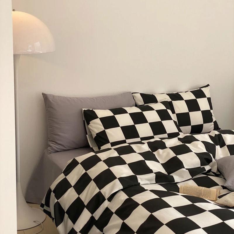 Side left view of the VibeCore Aesthetic Checkered Duvet Cover Set in black and white, emphasizing its bold checkered pattern and soft, breathable 100% cotton fabric. A stylish and cozy addition to any modern bedroom or dorm space.