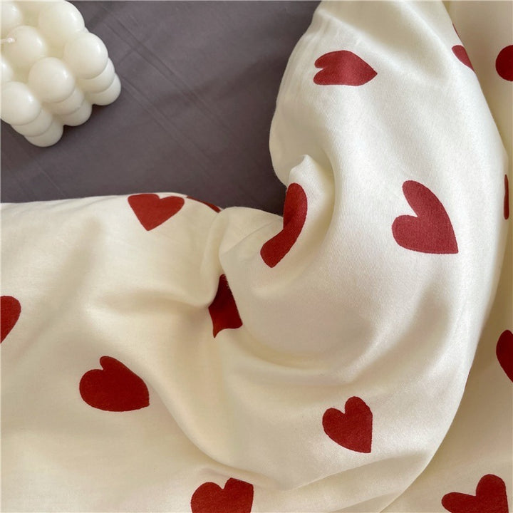 Close-up of the heart details on the pattern of the VibeCore Crimson Love Bedding Set, showcasing the vibrant crimson hearts on a soft cotton-polyester blend fabric.