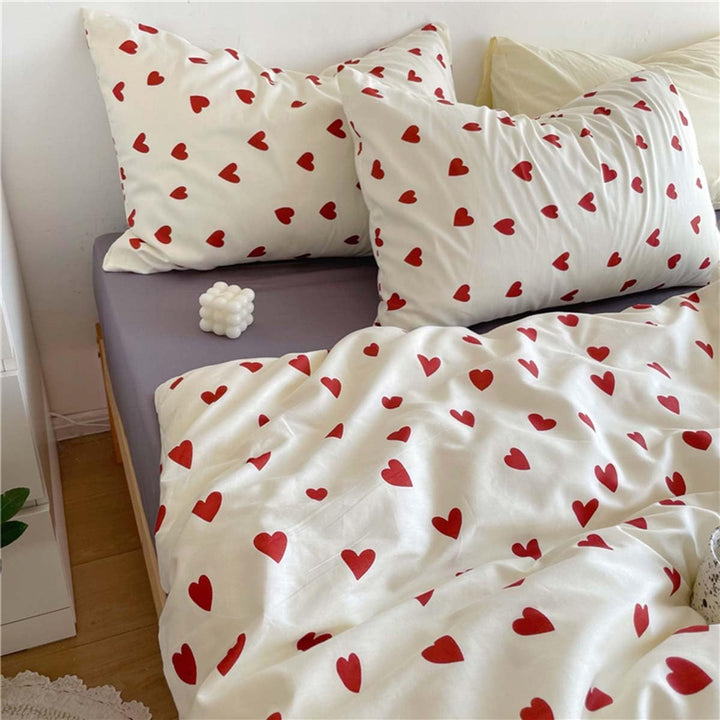 Close-up of the heart pattern and pillow covers of the VibeCore Crimson Love Bedding Set, showcasing the soft cotton-polyester fabric and bold crimson hearts for a cozy, romantic touch in your bedroom or dorm.