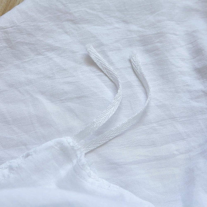Close-up of the stylish tie feature on the white duvet cover from the VibeCore Aesthetic Knot So Ordinary Duvet Cover Set, showcasing the trendy design detail that adds a unique, fashionable touch to your bedding.
