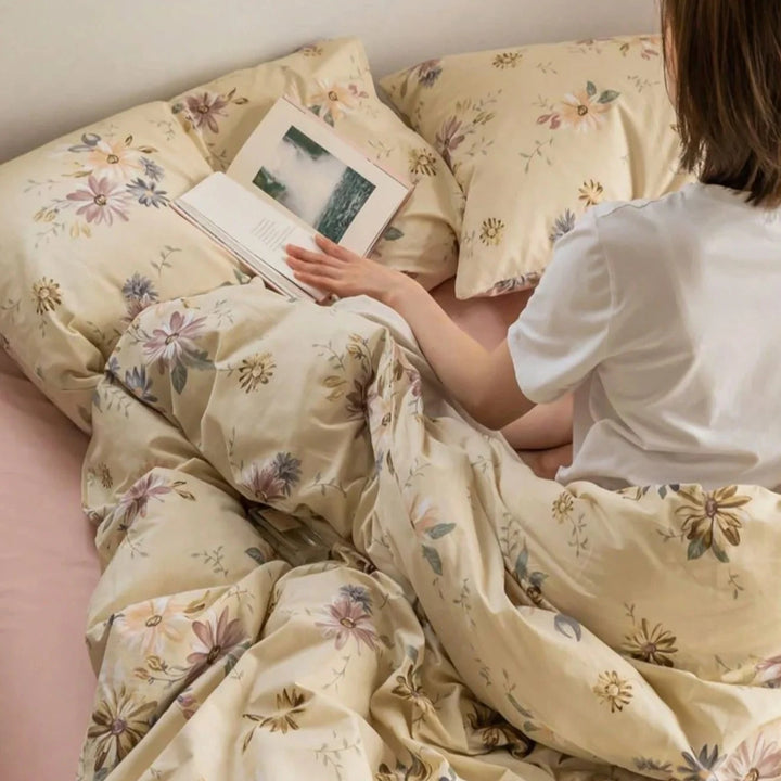Close-up of a girl lying in bed with the VibeCore Aesthetic Wildflower Whisper Duvet Cover, highlighting the cozy, nature-inspired floral design and soft, breathable fabric of the bedding set.