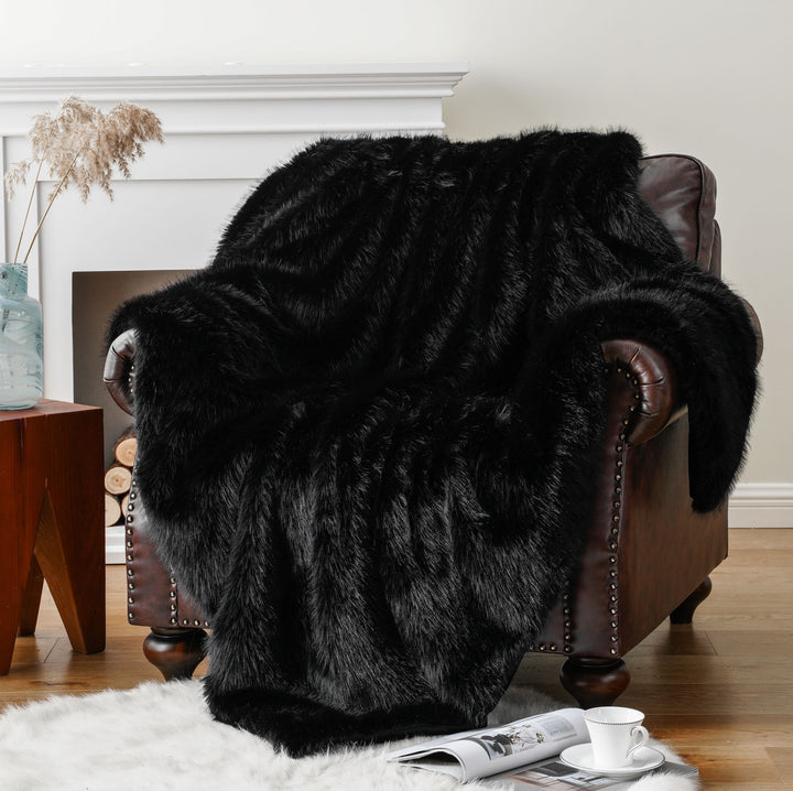 Black Arctic Dream Faux Fur Throw Blanket draped over a sofa chair, offering a chic, European-inspired design and plush comfort. A stylish and cozy addition to any living space.