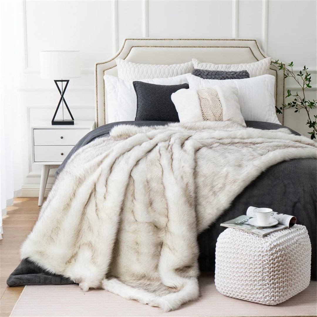 White Arctic Dream Faux Fur Throw Blanket draped over a bed, adding a touch of European elegance and luxurious comfort. Soft, plush, and perfect for enhancing your bedroom decor.