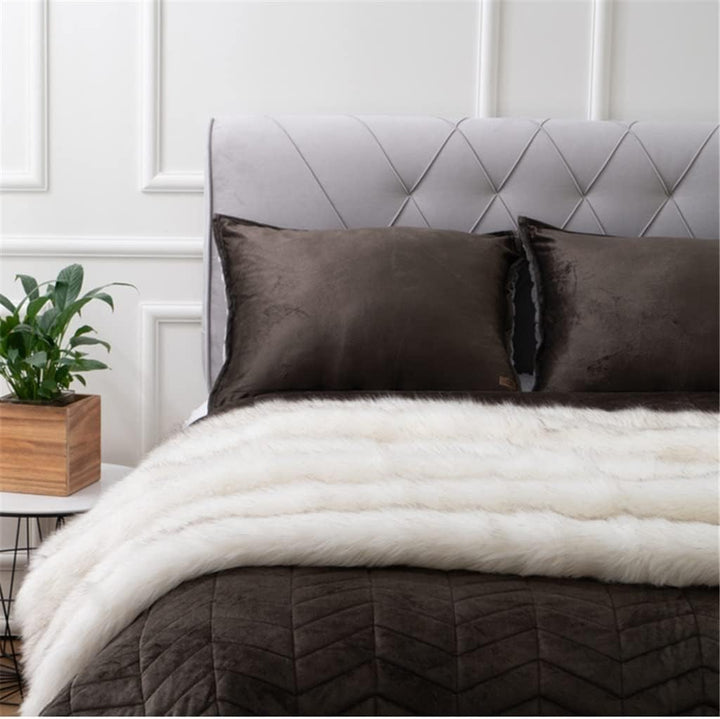 White Arctic Dream Faux Fur Throw Blanket draped over the end of a bed, adding a luxurious, European-inspired touch. Soft, plush, and perfect for enhancing your bedroom with cozy elegance.