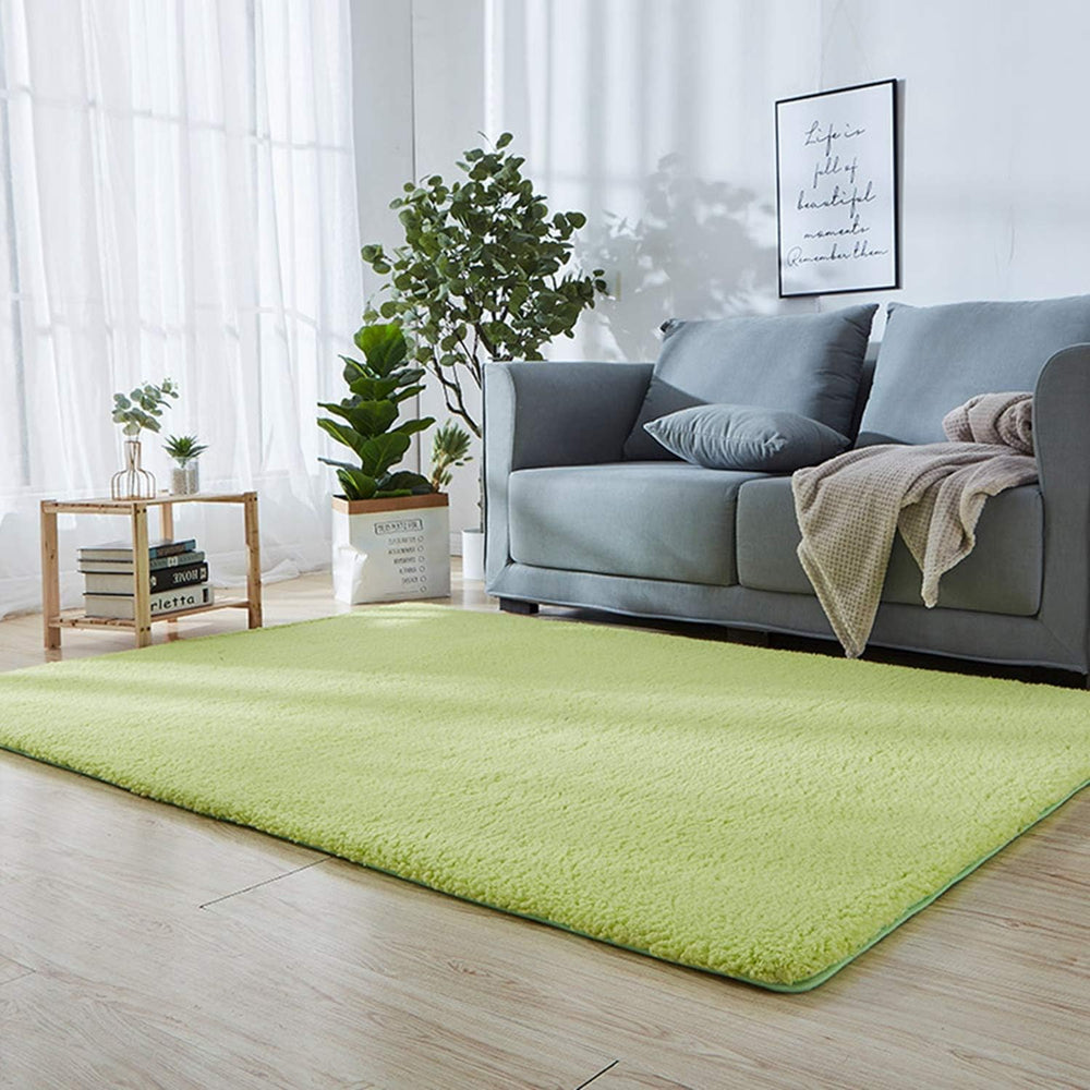 VibeCore Arctic Faux Cashmere Area Rug in matcha green placed in a living room, featuring a soft faux cashmere texture with non-slip backing. Adds warmth and luxury to any space, perfect for enhancing comfort and style. Easy to clean and available in 11 color options.