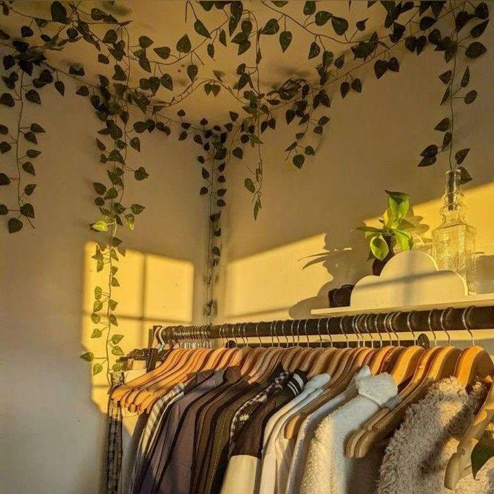 VibeCore Artificial Vine Garland Bundle above a clothing rack, featuring lush fake ivy vines that add vibrant greenery and a natural, boho touch to the space. These flexible, low-maintenance vines effortlessly enhance your room decor, creating a stylish and cozy atmosphere.