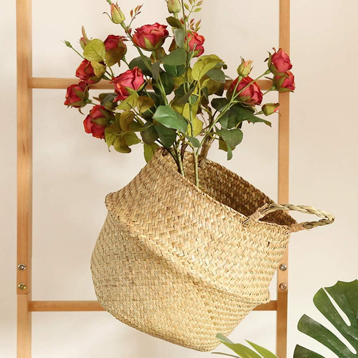 VibeCore BONO Handmade Wicker Basket with a plant, hanging from a ladder. Showcasing its handwoven organic wicker design, this stylish piece adds a natural, boho-inspired touch to any space.