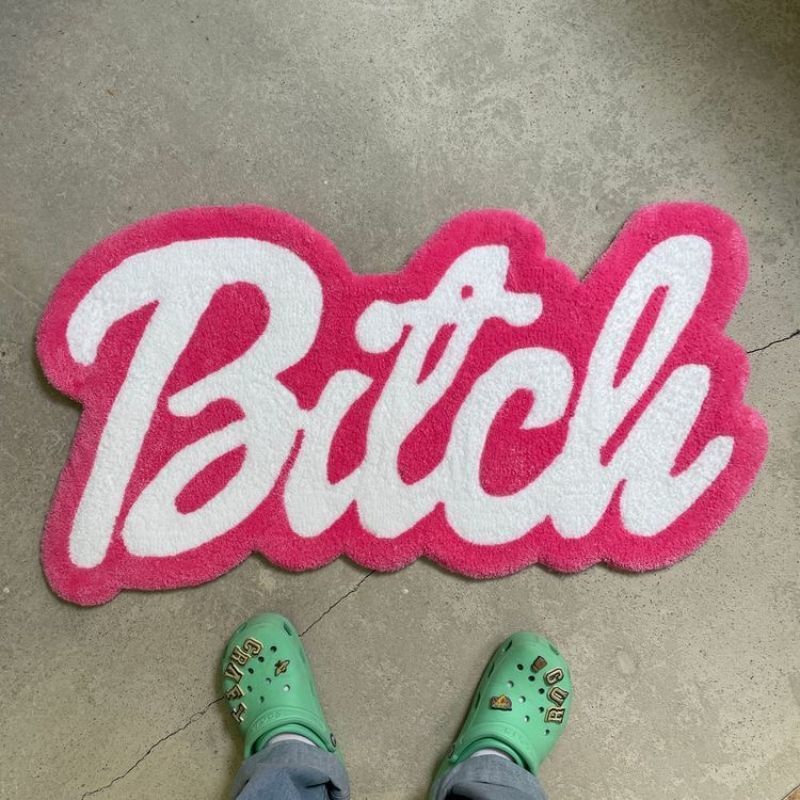 VibeCore Barbie Bitch Accent Rug on floor, showcasing its vibrant pink color, bold design, and plush texture, perfect for adding personality to any room.
