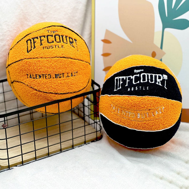 Round basketball decorative pillow in orange and black & orange with realistic detailing, placed on a bed or couch. Sporty throw pillow for dorms, teen bedrooms, or apartments, adding a game-inspired aesthetic.