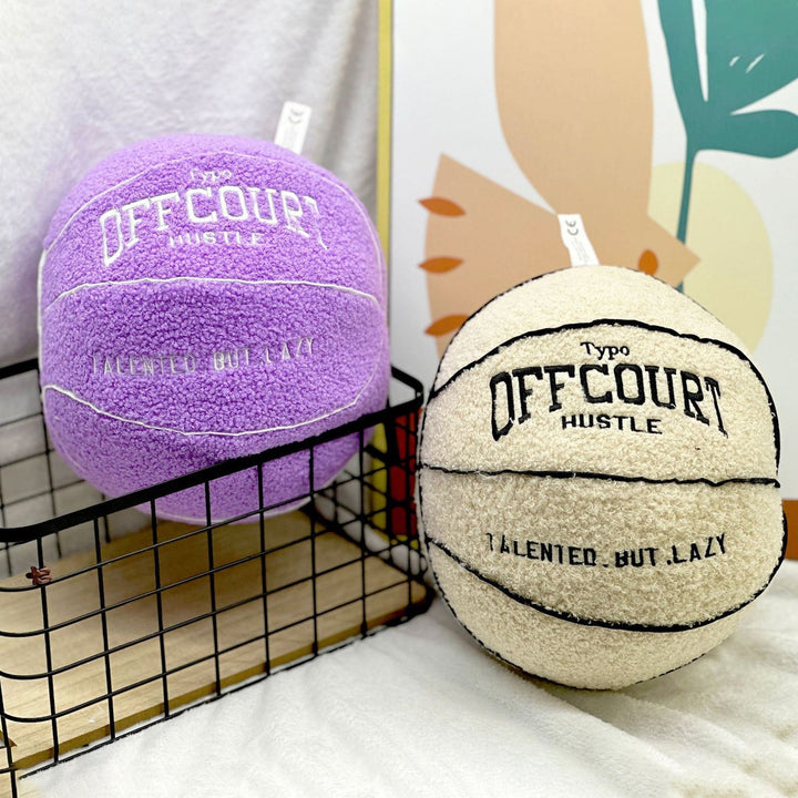 Round basketball decorative pillow in purple and white with realistic detailing, placed on a bed or couch. Sporty throw pillow for dorms, teen bedrooms, or apartments, adding a game-inspired aesthetic.