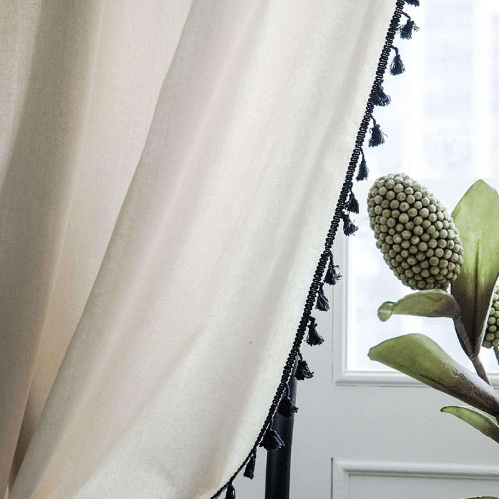 Close-up of beige tassel linen curtain, highlighting the delicate tassel accents.
