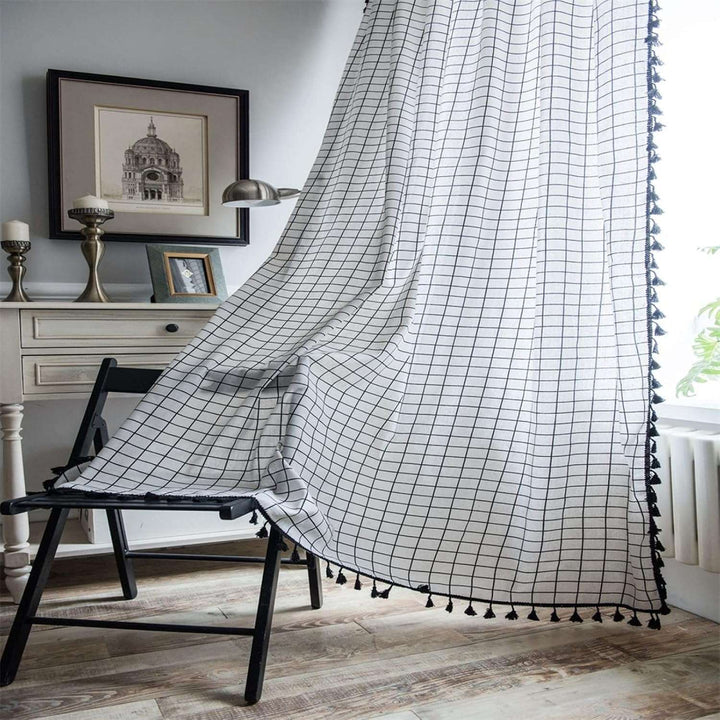 VibeCore Black & White Grid Tassel Linen Curtain in apartment, showcasing a bold grid pattern with playful tassels, light-filtering design crafted from a soft cotton-linen blend, ideal for adding contemporary bohemian style to your space.