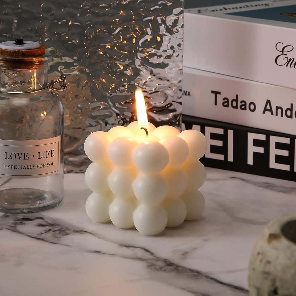 Aesthetic white bubble cube candle lit with a warm glow featuring a chic cube shape playful bubble design and fresh pear freesia scent perfect for cozy home decor