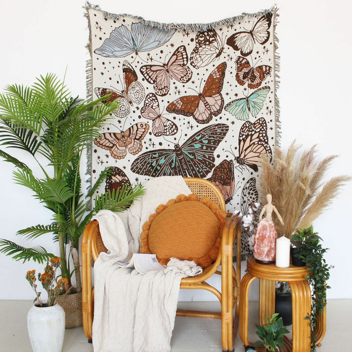 VibeCore Butterflies Woven Blanket as a wall hanging, featuring vibrant butterfly design and soft 100% combed cotton texture.