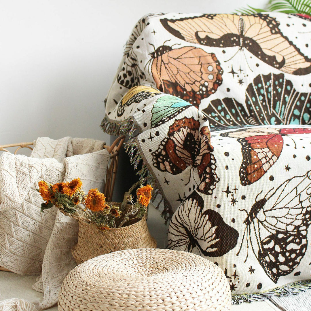 VibeCore Butterflies Woven Blanket draped over chair, close-up showcasing vibrant butterfly design and soft 100% combed cotton texture.