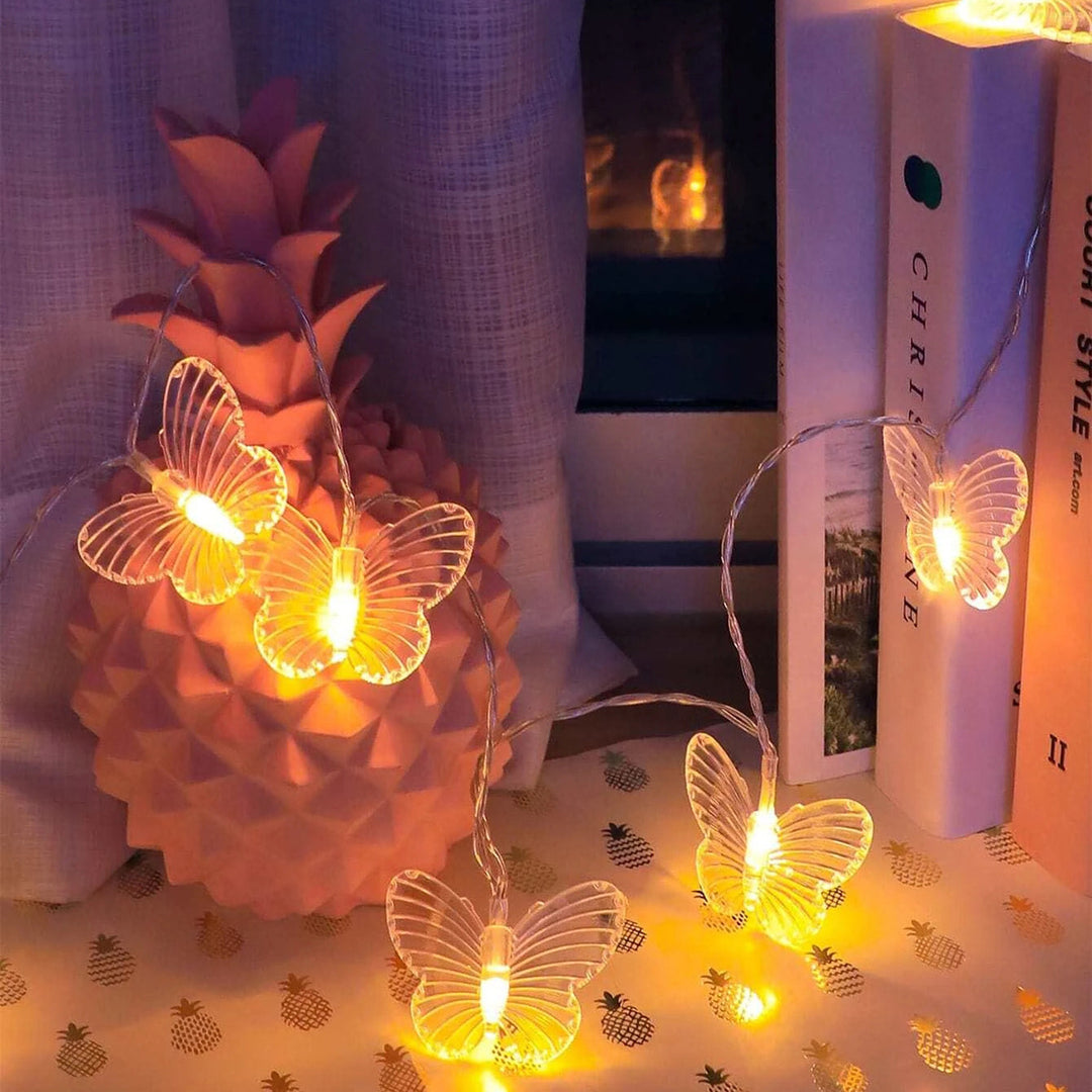 VibeCore Butterfly String Lights displayed on a shelf, illuminating the space with a soft, warm white glow and delicate butterfly designs.