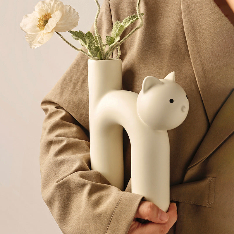 VibeCore Cat Ceramic Vase in beige being carried, highlighting its smooth ceramic finish and cute cat-shaped design.