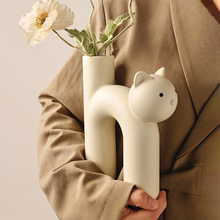 VibeCore Cat Ceramic Vase in beige being carried, highlighting its smooth ceramic finish and cute cat-shaped design.