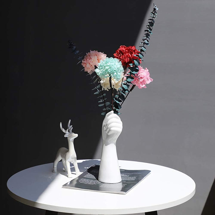 VibeCore Ceramic Hand Vase holding flowers, elegant hand-shaped design in porcelain, showcasing artificial flowers for a timeless and minimalist decor.