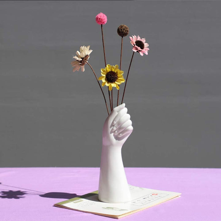 VibeCore Ceramic Hand Vase holding a few artificial flowers, elegant hand-shaped porcelain design, perfect for adding a creative and minimalist touch to your decor.