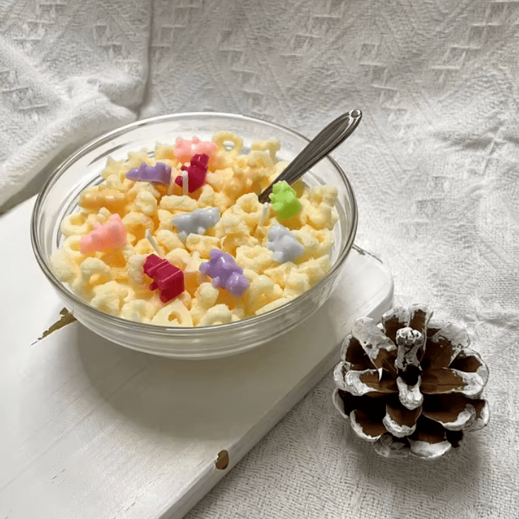 Side view of VibeCore Cereal Bowl Candle designed like Cheerios with gummy bears, showing detailed soy wax cereal pieces in a white bowl for cute room decor.