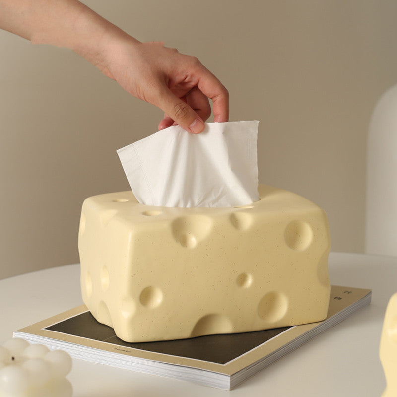 A playful, cheese-shaped tissue box in ceramic, with a tissue being pulled out, adding quirky charm to any space. Ideal for fun and functional decor in bedrooms, bathrooms, or living rooms.