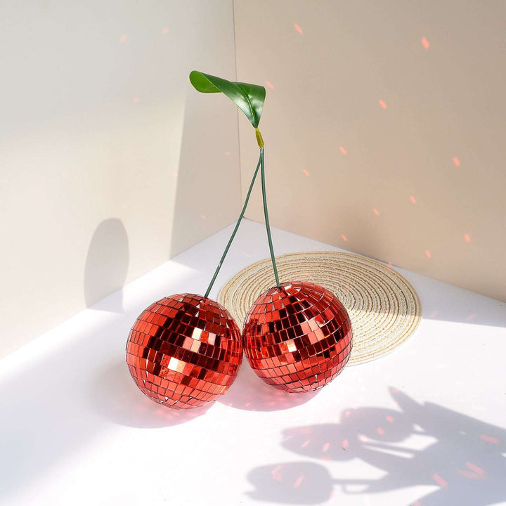 VibeCore Cherry Disco Ball Red on table, showcasing its vibrant mosaic finish and geometric design, adding a playful and eye-catching touch to your home decor.