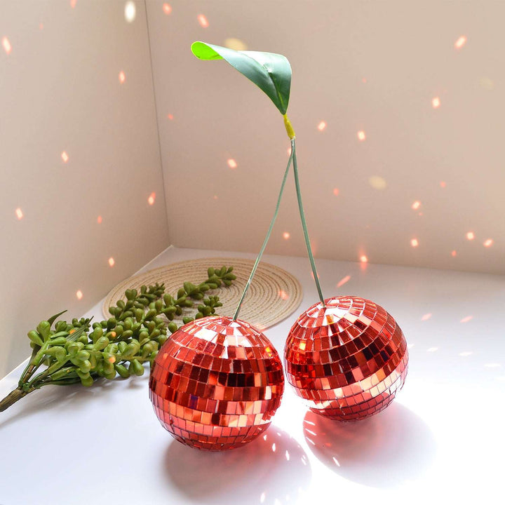 VibeCore Cherry Disco Ball Red reflecting light, showcasing its dazzling mosaic finish and vibrant color, creating a playful and radiant ambiance in any room.