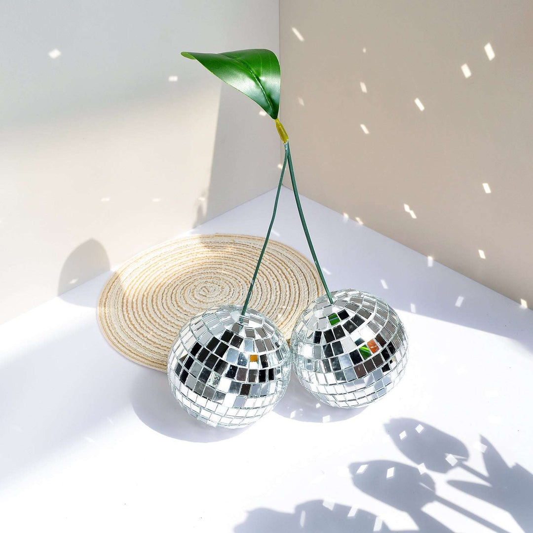 VibeCore Cherry Disco Ball Silver reflecting light, with its shimmering silver mosaic surface creating a dazzling and vibrant atmosphere that adds playful elegance to any room.