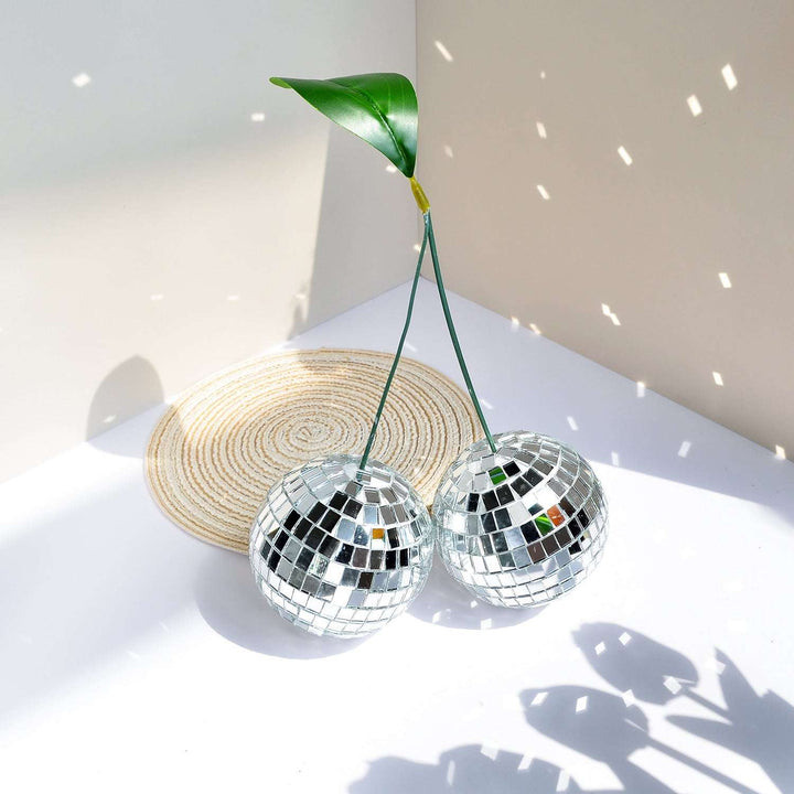 VibeCore Cherry Disco Ball Silver reflecting light, with its shimmering silver mosaic surface creating a dazzling and vibrant atmosphere that adds playful elegance to any room.