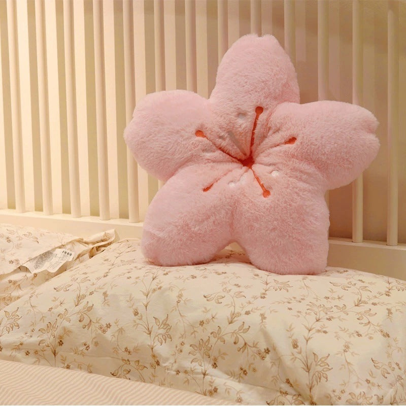 VibeCore Cherry Petal Throw Pillow on a bed, showcasing its playful floral design in baby pink, yellow, and sky blue. Made from soft plush PP cotton, this pillow adds a fun, spring-inspired touch and a cozy pop of color to your space.