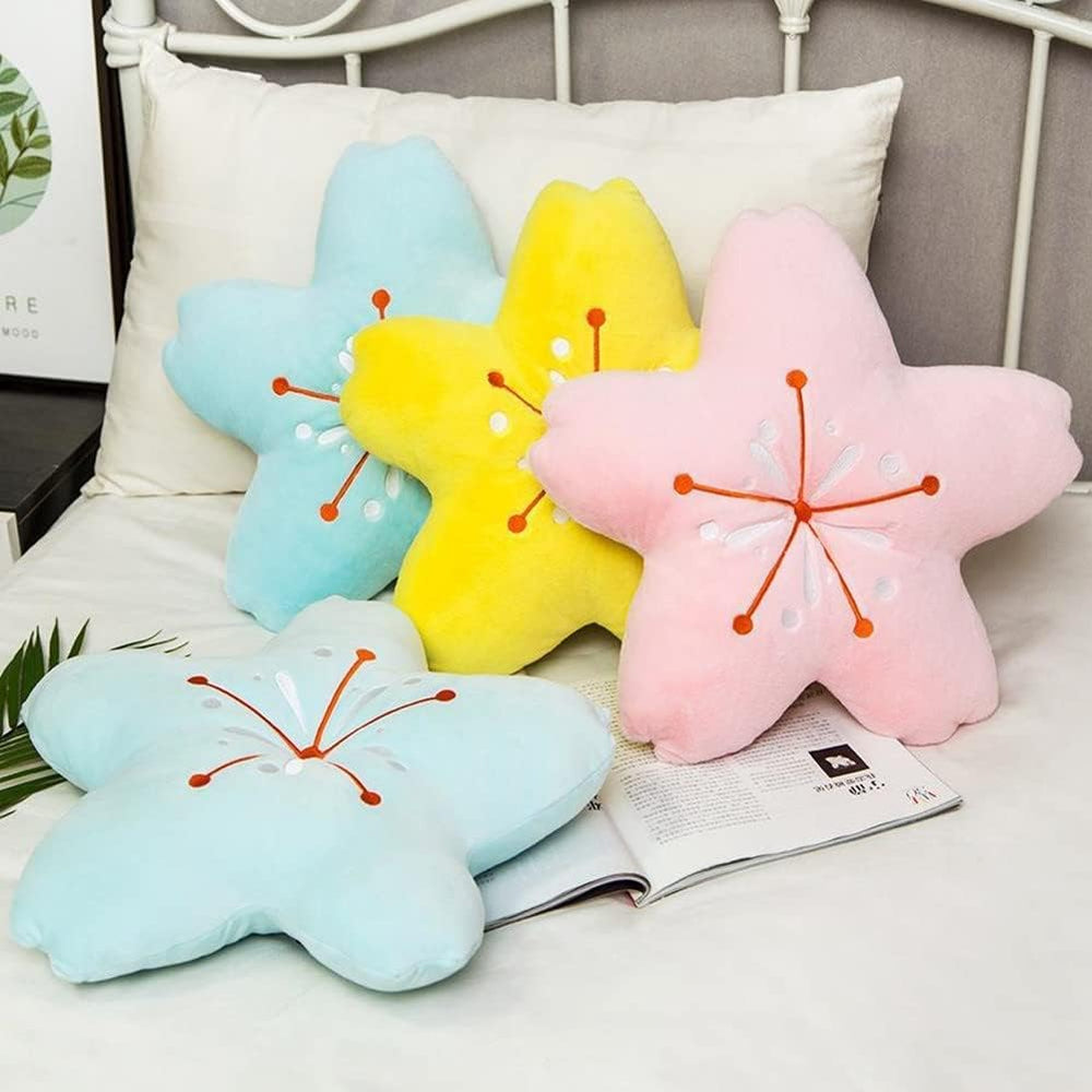 VibeCore Cherry Petal Throw Pillow on a bed, featuring all three colors—baby pink, yellow, and sky blue. The playful floral design and soft plush PP cotton add a fun, spring-inspired touch and cozy charm to your space.