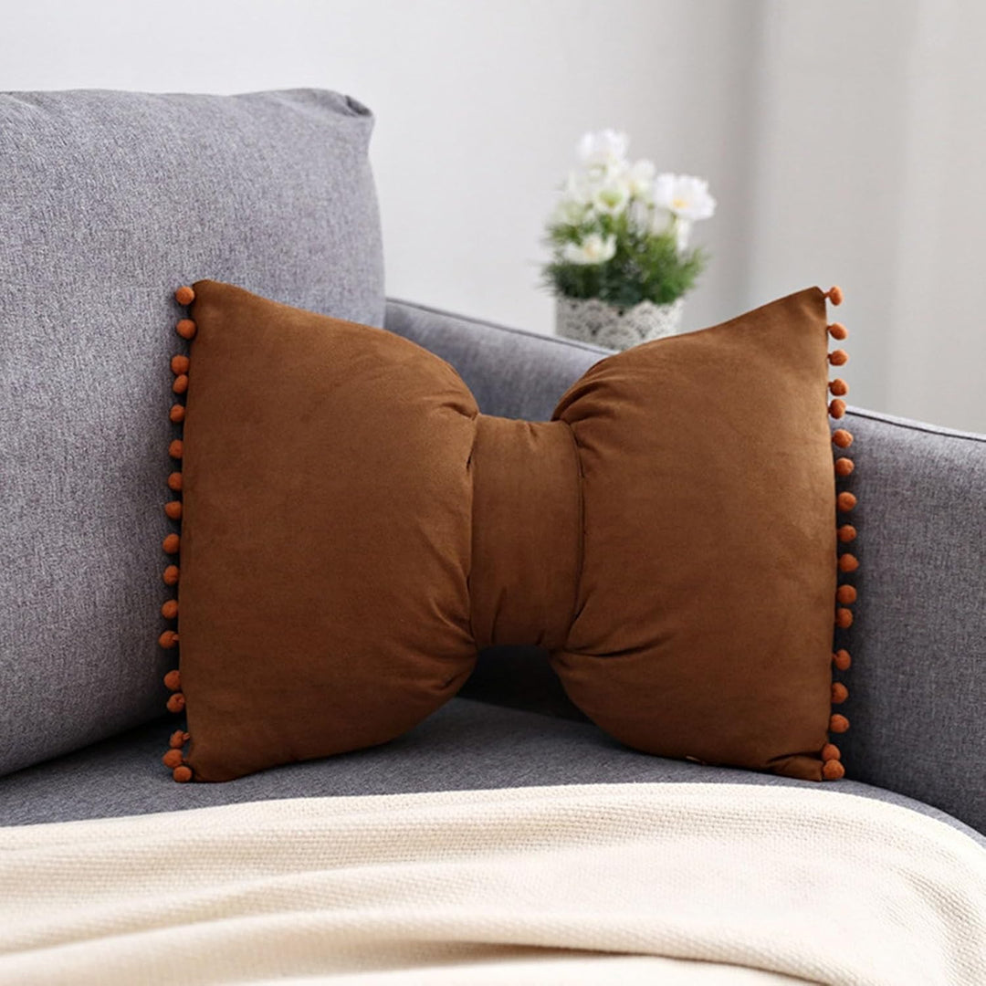 VibeCore Classic Bow Throw Pillow in brown, featuring a playful bow design with pom-poms on the edges, adding a warm and stylish accent to your space.