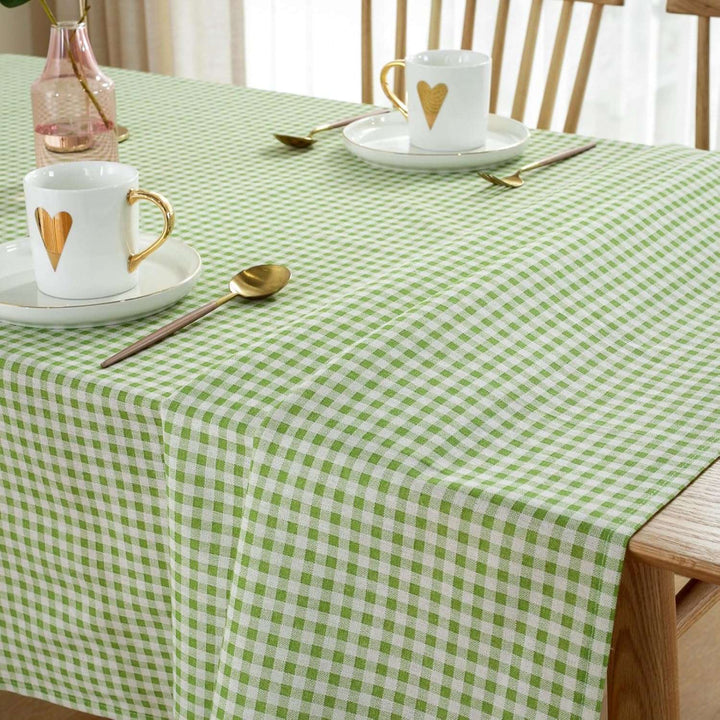 VibeCore Classic Picnic Plaid Tablecloth green close up on table, highlighting the vibrant plaid pattern and smooth, fade-resistant fabric, perfect for adding charm to any table setting.