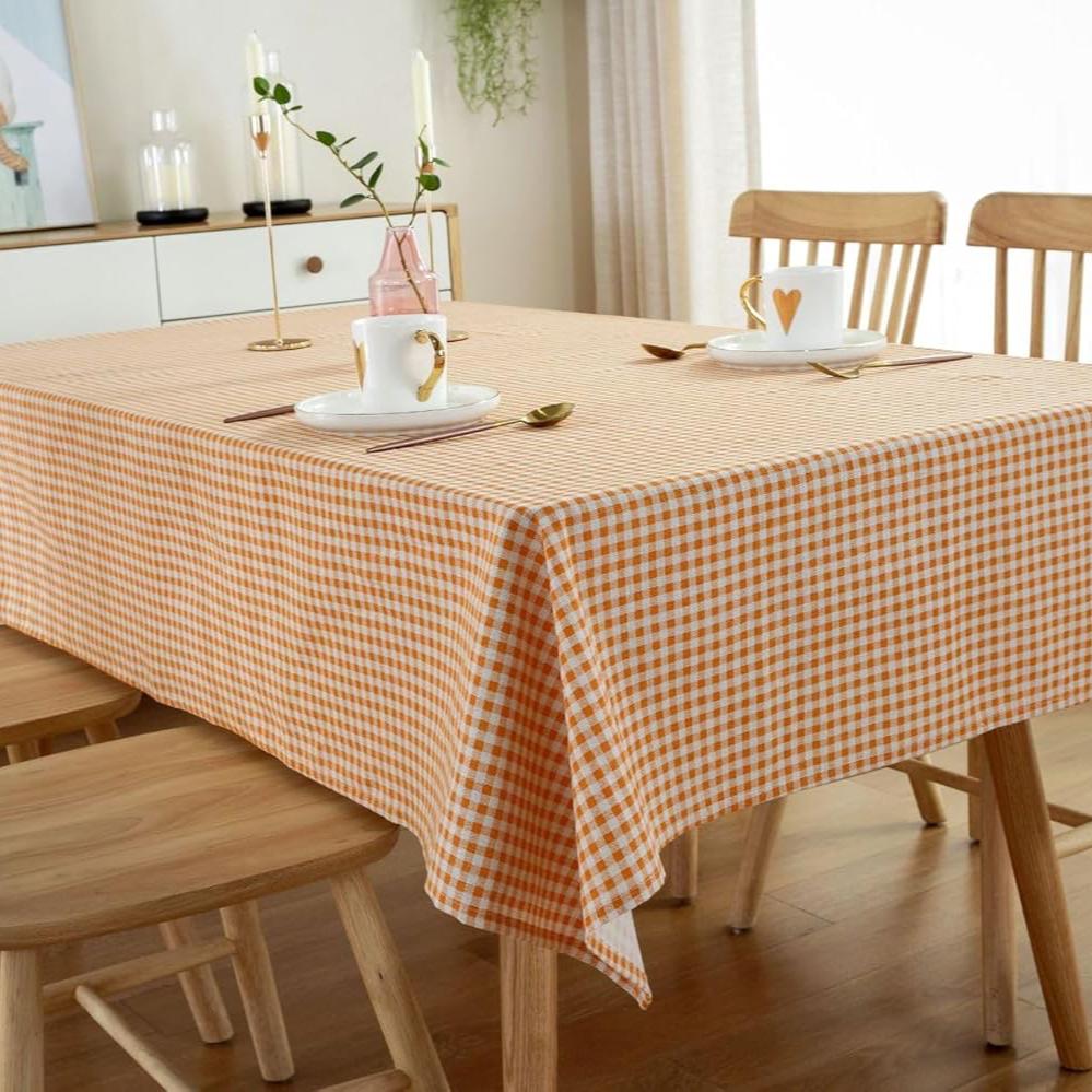 VibeCore Classic Picnic Plaid Tablecloth orange on table, showcasing a vibrant plaid design with waterproof, fade-resistant fabric, perfect for stylish table settings at any gathering.