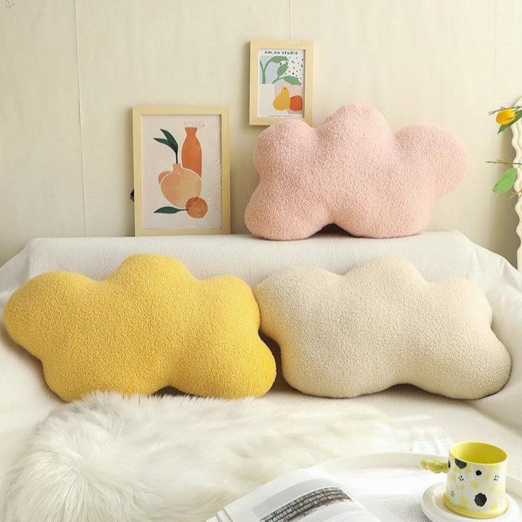 VibeCore Cloud Throw Pillows in white, pink, and yellow, arranged on a couch, featuring their fluffy, cloud-shaped design. Made from soft PP cotton, these dreamy pillows add a serene, calming touch to your space, enhancing your decor with ultimate comfort and a tranquil vibe.