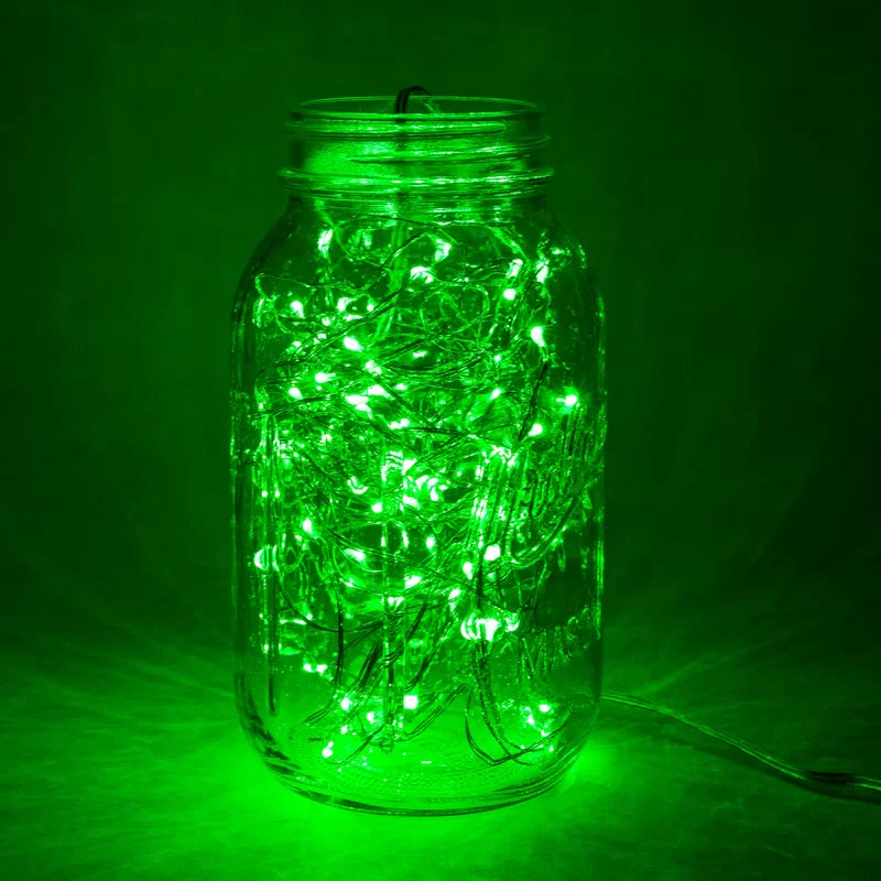 Close-up of VibeCore copper fairy lights in green, glowing softly with a vibrant, nature-inspired hue.
