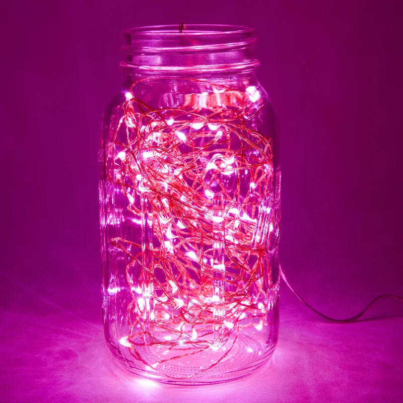 Close-up of VibeCore copper fairy lights in pink, glowing softly to create a cozy, vibrant atmosphere.