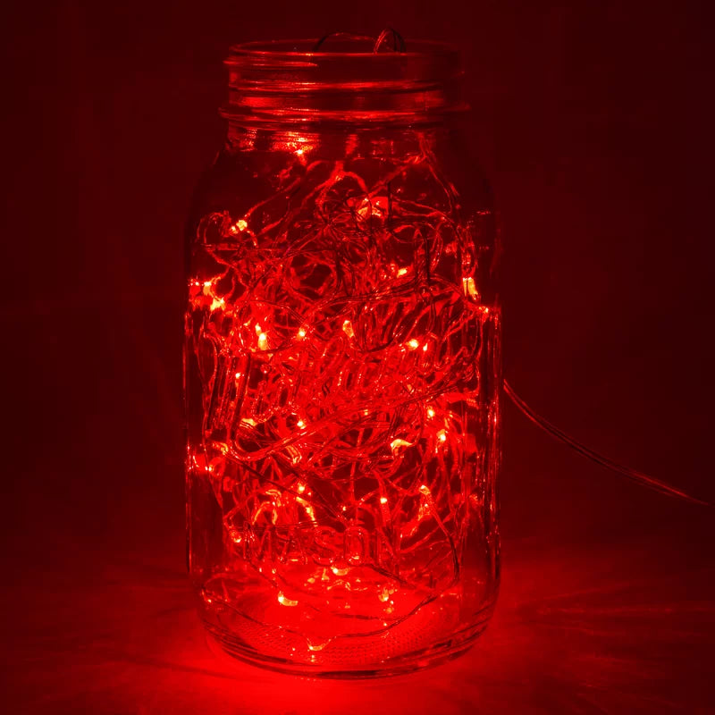 Close-up of VibeCore copper fairy lights in red, glowing softly with a warm, vibrant light.
