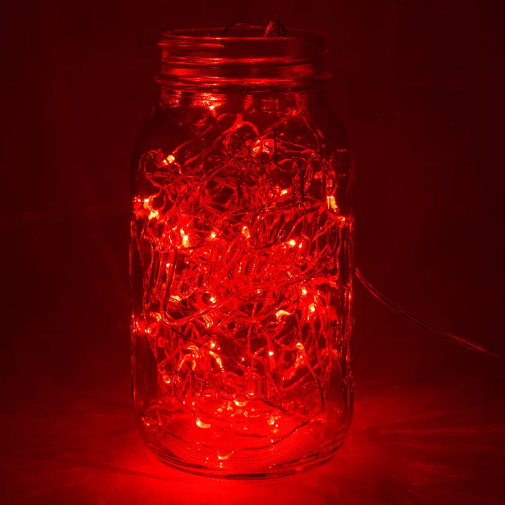 Close-up of VibeCore copper fairy lights in red, glowing softly with a warm, vibrant light.