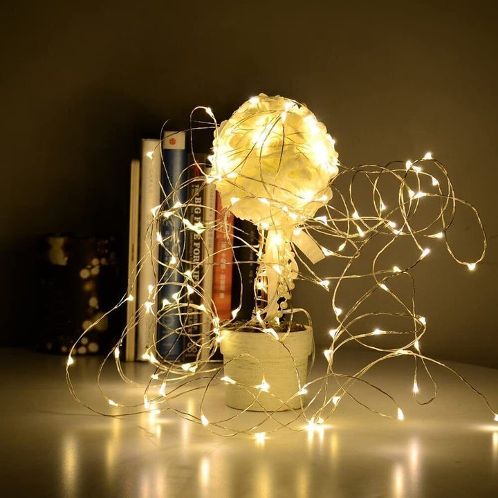 VibeCore copper fairy lights in warm white, draped on a table, adding a soft, cozy glow to the space.