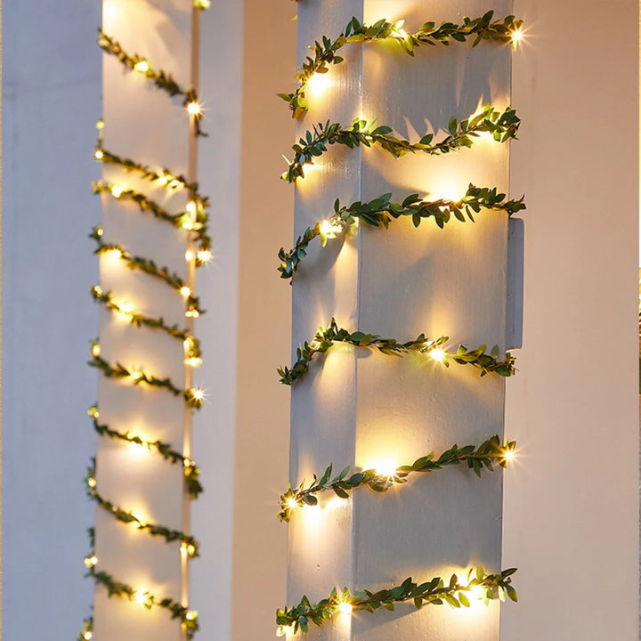 VibeCore copper leaf garland string lights wrapped around a post, creating a warm, glowing ambiance with lush, artificial leaves for a cozy and vibrant touch.