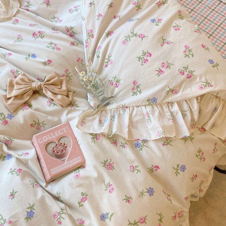 Close-up of the floral design and ruffles on the 'Blossom French Ruffles Bedding Set,' highlighting the intricate details and delicate texture. The soft fabric features elegant floral patterns and feminine ruffles, adding a romantic and coquette touch to any bedroom or dorm.